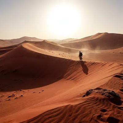 A vast desert landscape with giant red sand dunes, a lonely nomad walking in the distance, intense scorching sun, cinematic wide angle shot, 4k. A vast desert landscape with giant red sand dunes, a lonely nomad walking in the distance, intense scorching sun, cinematic wide angle shot, 4k.